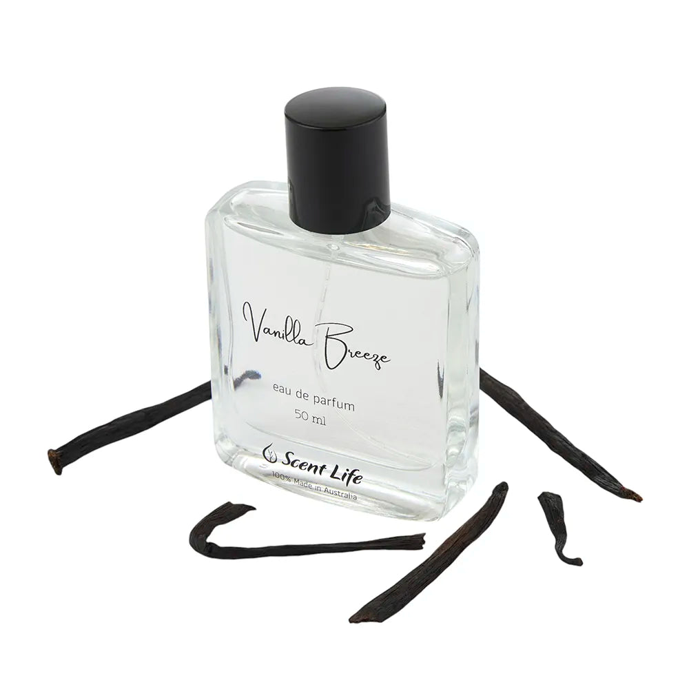 A clear glass bottle of Scent Life's Vanilla Breeze eau de parfum, featuring a black cap, is set against a white background. The fragrance bottle is elegantly surrounded by vanilla pods.